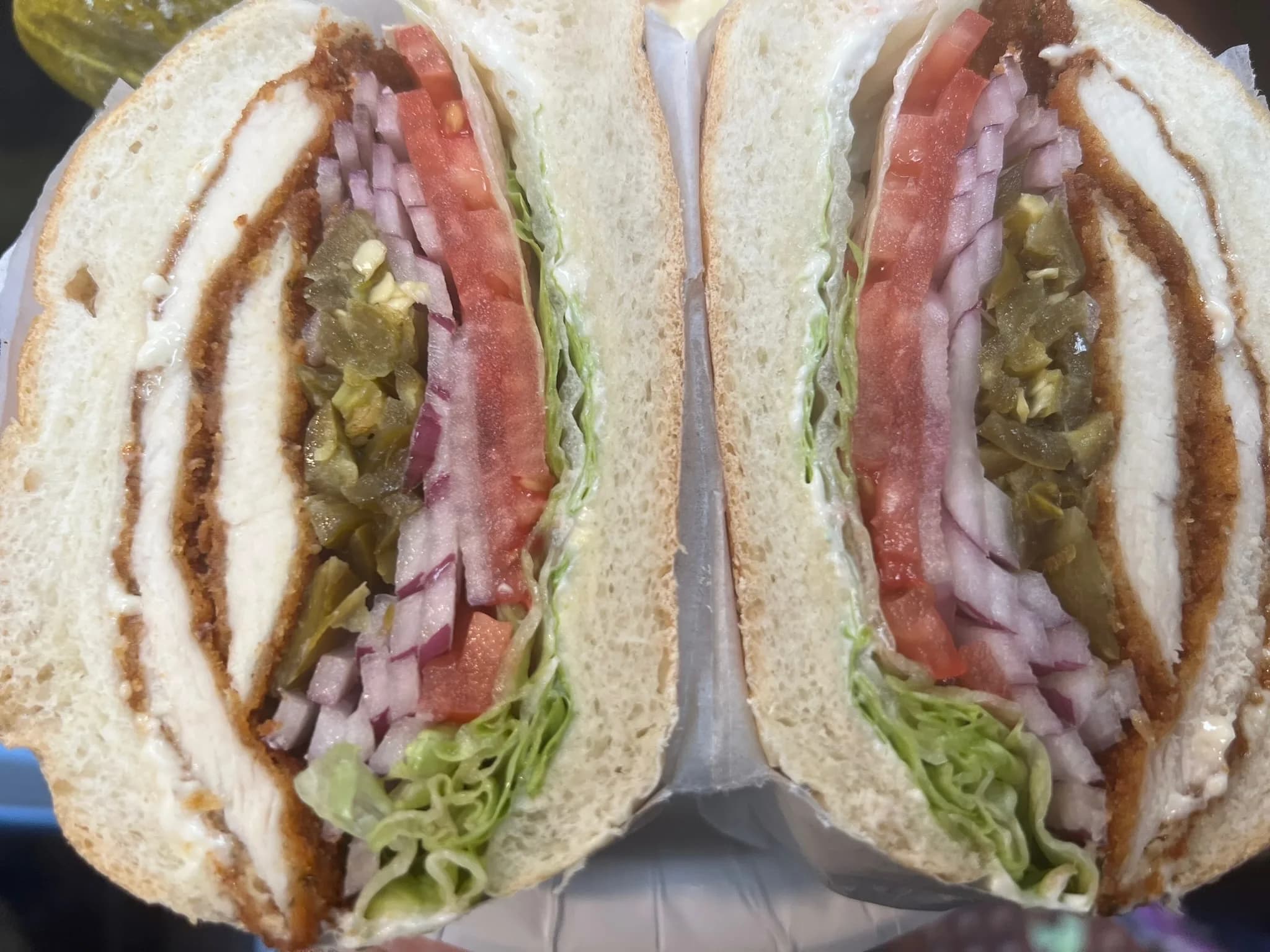 The Brooklyn Bomb — breaded chicken cutlet stacked with fresh tomato, jalapeños, red onion, and crisp lettuce