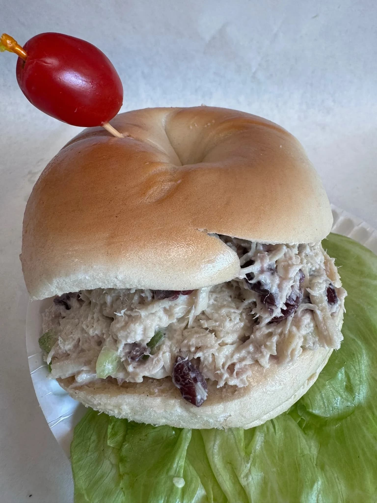 Cranberry chicken salad on a plain bagel with crisp lettuce