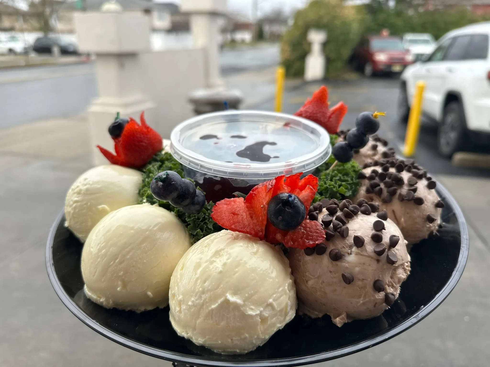 Two generous scoops of cream cheese plated with fresh strawberries and blueberries