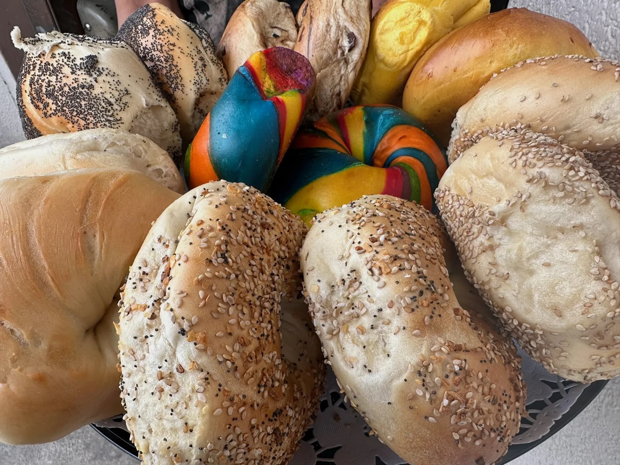 Assorted fresh New York bagels in a basket at Howard Beach Bagel Cafe