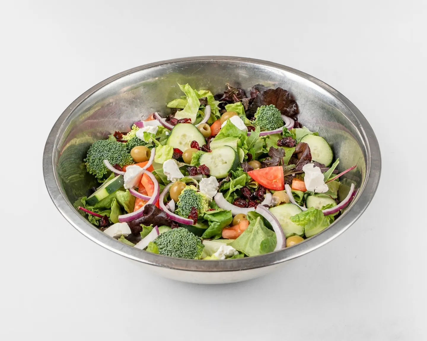 A loaded Greek-style chopped salad — peppers, olives, tomato, feta, and red onion over crisp greens