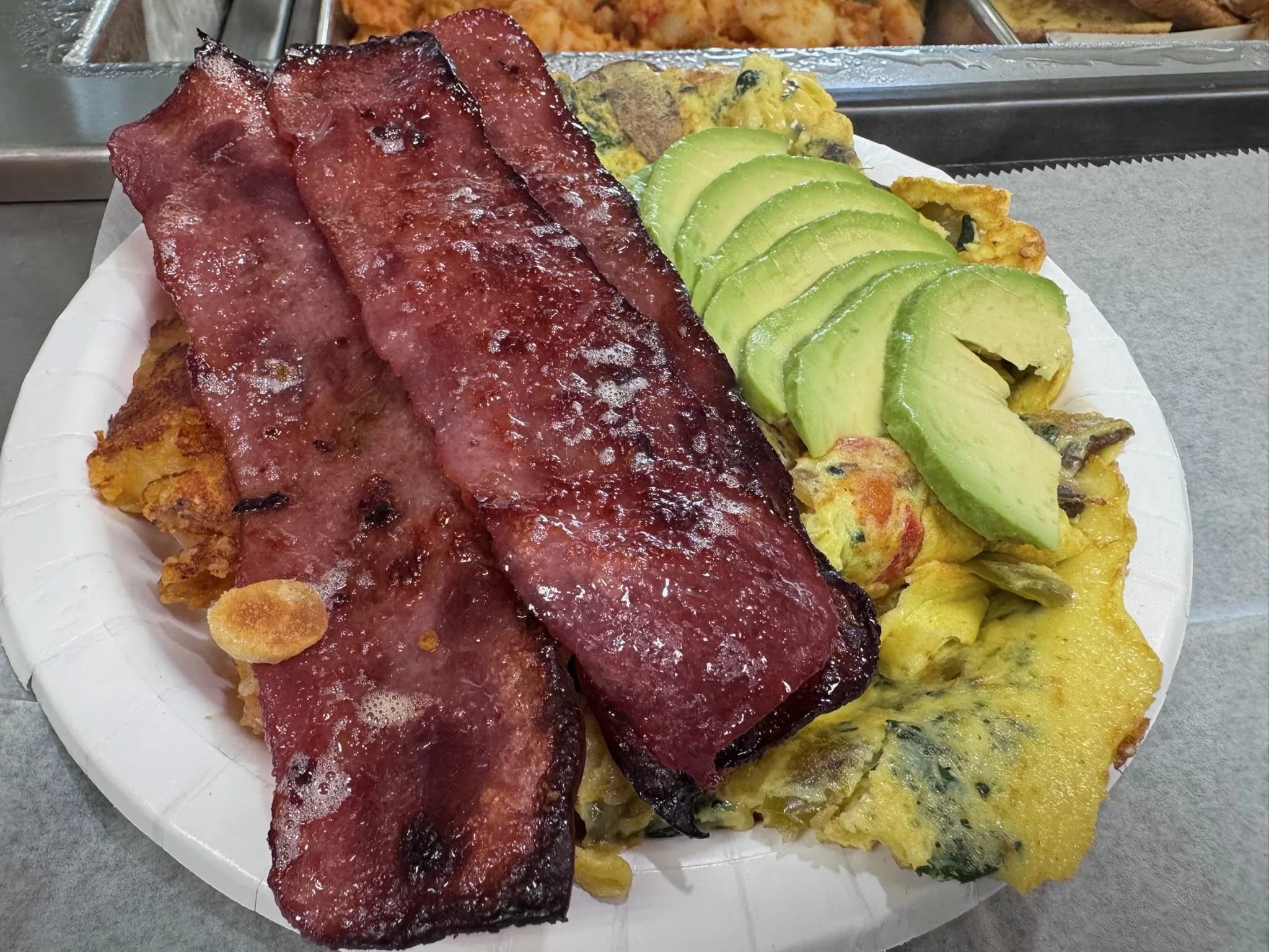 Omelette with turkey, bacon, and fresh avocado on the side